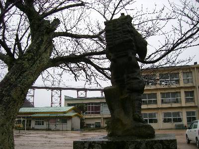 小学校校庭の二宮金次郎像と余部鉄橋