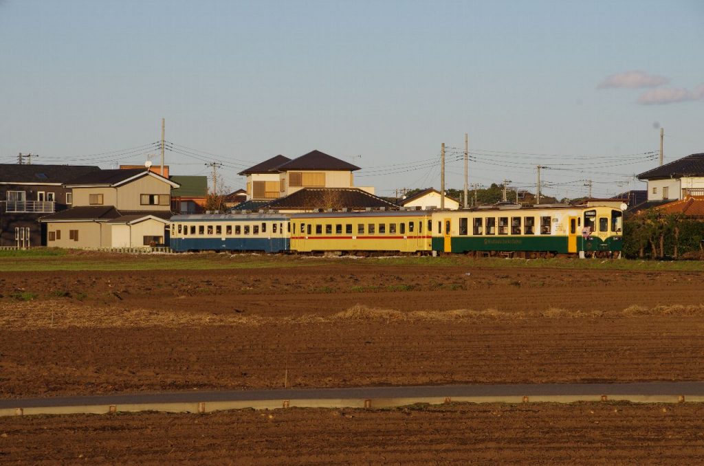 田園風景の中を走るキハ 222 を含む 3 両編成の列車