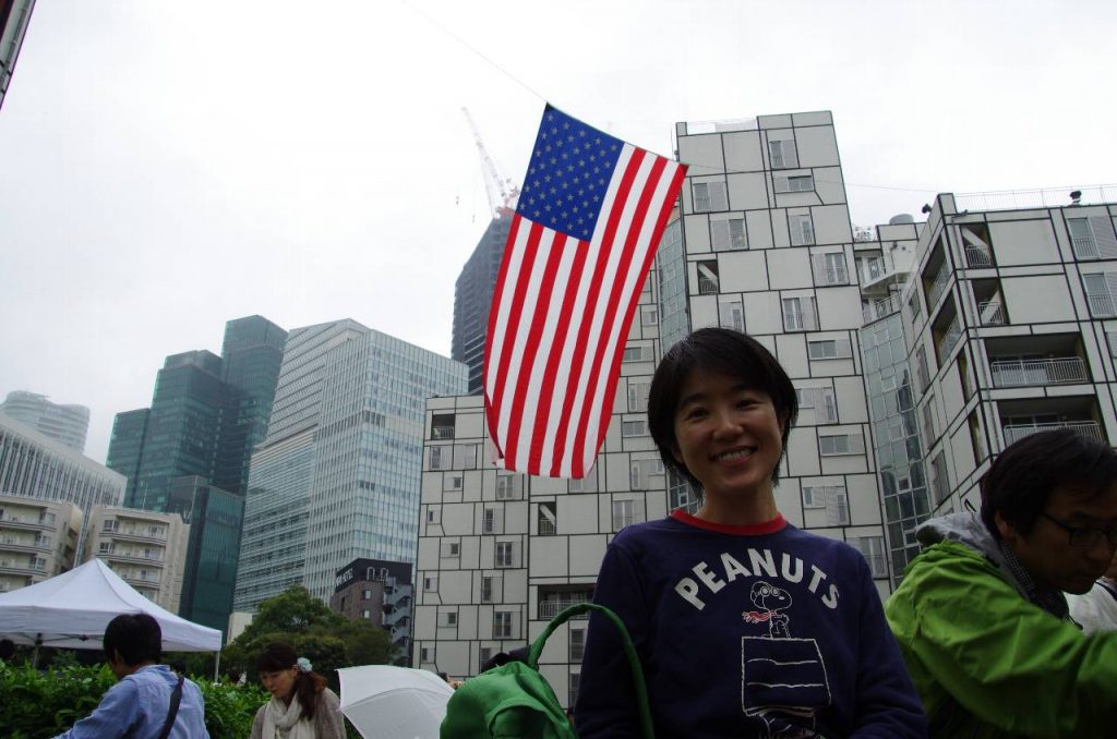 大きな星条旗を背景に妻の記念写真