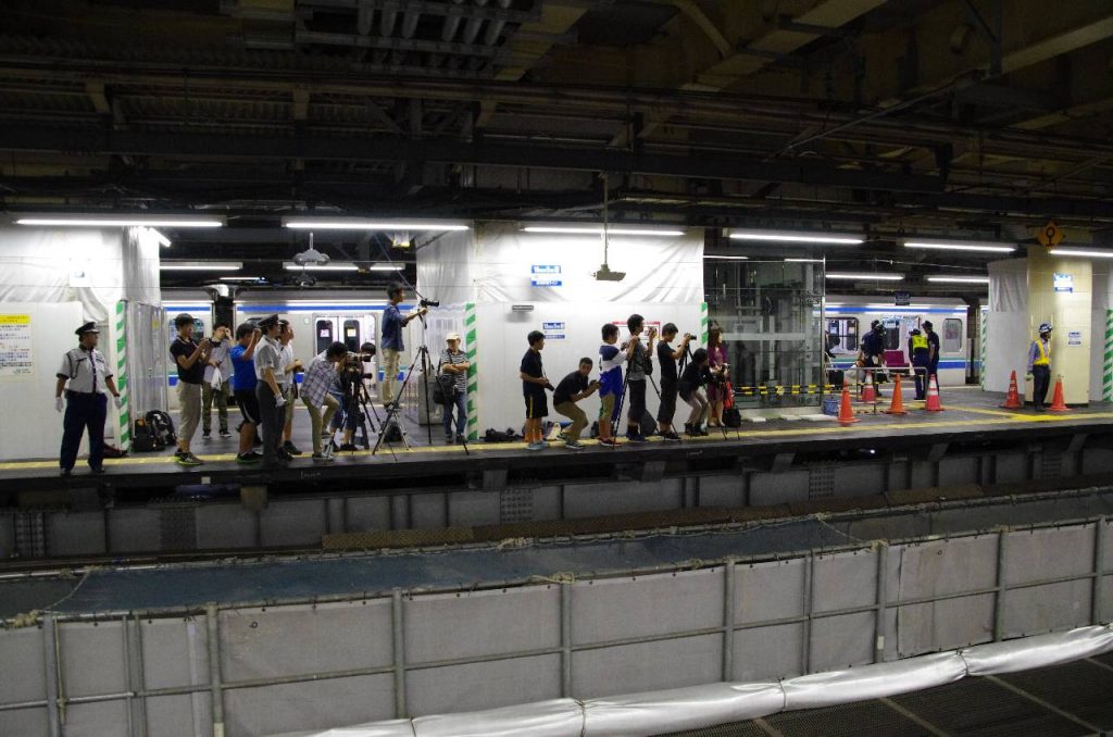 新宿駅 4 番線で 5 番線に入ってくる「あおもり」号を待つ人々